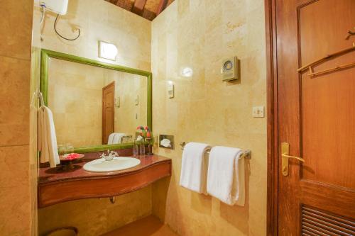 a bathroom with a sink and a mirror at Villa Chempaka in Ubud