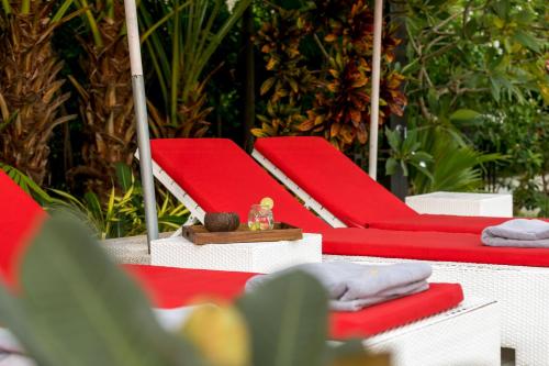 a row of red chairs with a small toy on top at Beachfront Villa Baan Paradise in Laem Set Beach