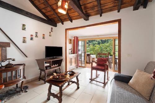 a living room with a television and a table at Casa Rural Medina 1 in Agulo