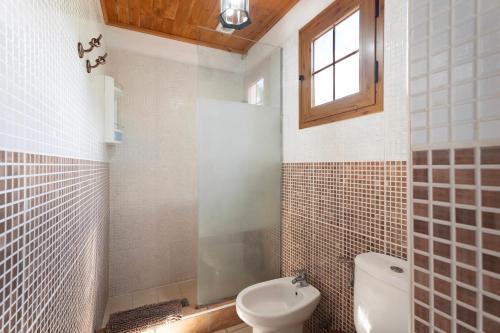 a bathroom with a toilet and a sink and a window at Casa Rural Medina 1 in Agulo