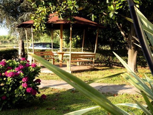 a wooden gazebo in a park with flowers at Voula Apartments in Mitikas