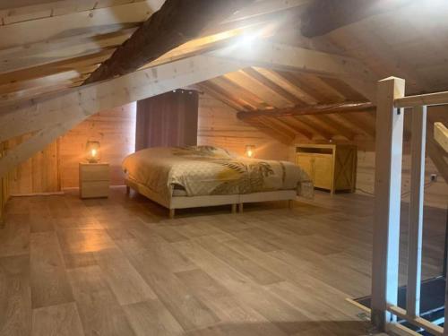 een slaapkamer met een bed op een zolder met houten plafonds bij Logement entier: appartement. in Modane