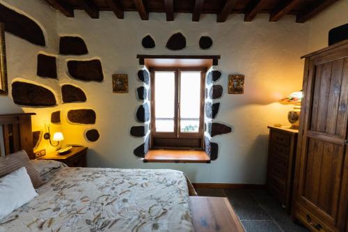 a bedroom with a bed and a window at Ancient Historical House in Santa Lucía