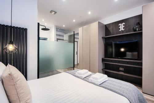 a bedroom with a bed and a flat screen tv at Circlelet Luxury Private Suite 1 in London