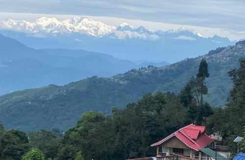 a view of a mountain range with snow capped mountains at Bloomfield Farmhouse and Eco-Resort in Darjeeling