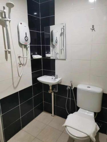 uma casa de banho com um WC e um lavatório em Mikayla Hotel em Port Dickson