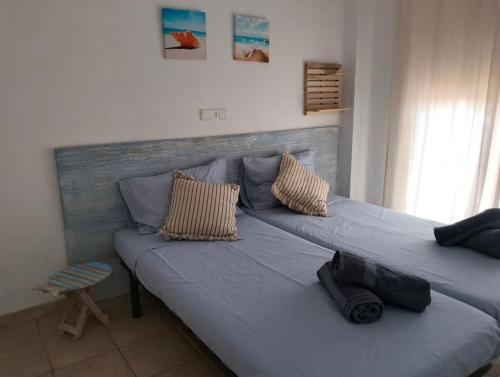 1 cama con 2 almohadas en una habitación en Apartamento con piscina junto a la playa, en Sant Antoni de Calonge