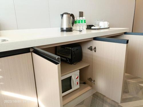 a kitchen with a counter top with a microwave at Fan's Hotel- Ormoc in Ormoc