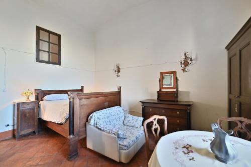 a bedroom with a bed and a chair and a mirror at Agriturismo Ma Che Bel Castello in Mombaruzzo