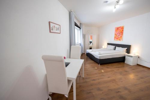 a bedroom with a bed and a desk in a room at Appartement im Zentrum von Baienfurt in Baienfurt