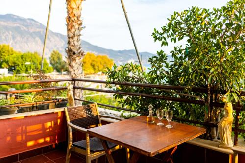 a wooden table and chairs on a balcony with mountains at Grand Luxury Apartment Seafront Kalamata in Kalamata