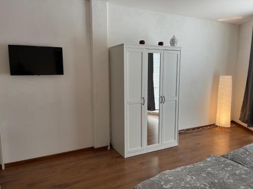 a white cabinet with a mirror in a room at Appartement im Zentrum von Baienfurt in Baienfurt