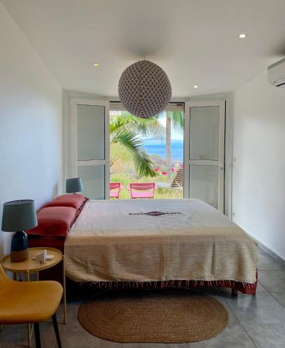Schlafzimmer mit einem großen Bett und Meerblick in der Unterkunft La Villa Trocas in Koungou