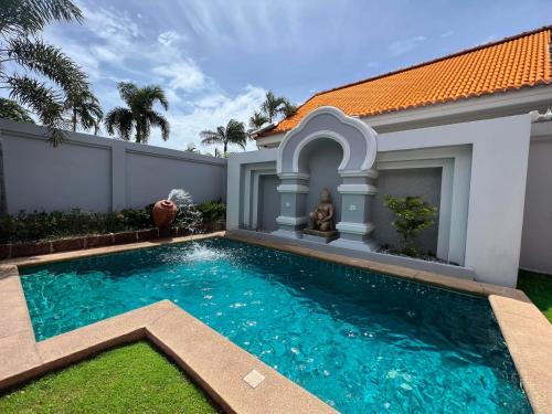 a swimming pool in the backyard of a house at Pattaya Jomtien Private Luxury Pool Villa 芭堤雅中天豪华私家泳池别墅 in Jomtien Beach