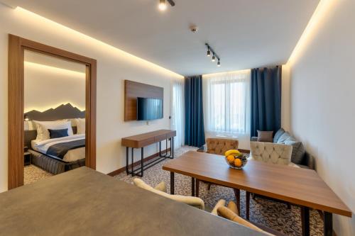 um quarto de hotel com uma cama e uma sala de jantar em Queen of Zlatibor em Zlatibor