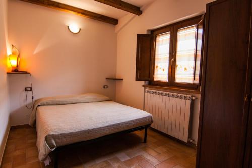 a small room with two beds and a window at Al Peschio Pizzuto Agriturismo in Scanno