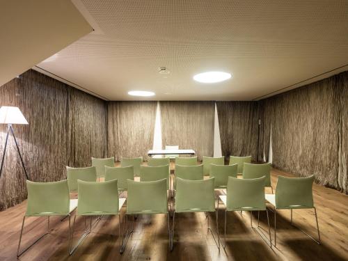 a conference room with green chairs and a table at Falkensteiner Family Hotel Sonnenalpe in Sonnenalpe Nassfeld
