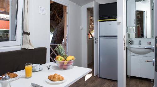 a kitchen with a table with a bowl of food on it at Mobile Homes Camp Perna - Adriatic Kampovi in Orebić