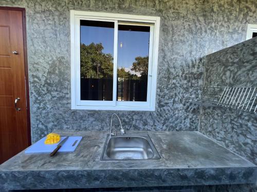 清萊的住宿－PePi-Resort，厨房设有水槽和窗户。