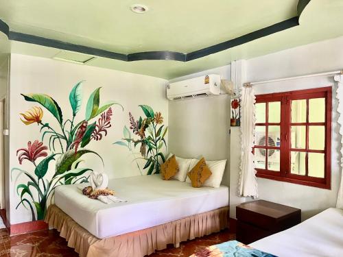 a bedroom with a bed with a mural on the wall at Koh Mook Garden Beach Resort in Ko Mook