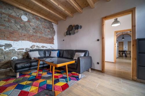 a living room with a leather couch and a table at Apartmánový dům Jeník in Nové Hrady