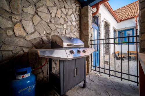 una parrilla junto a una pared de piedra en Apartmánový dům Jeník, en Nové Hrady