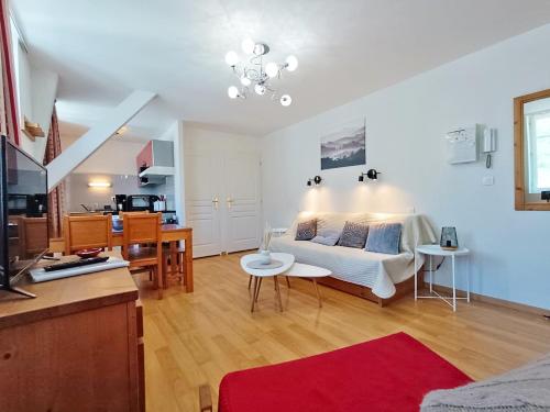 un salon avec un canapé et une cuisine dans l'établissement Le Venasque, T2, centre Luchon, wifi, casier à ski, ascenseur, 4 personnes, à Luchon