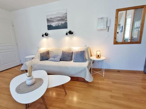 a white bedroom with a bed and a table at Le Venasque, T2, centre Luchon, wifi, casier à ski, 4 personnes in Luchon