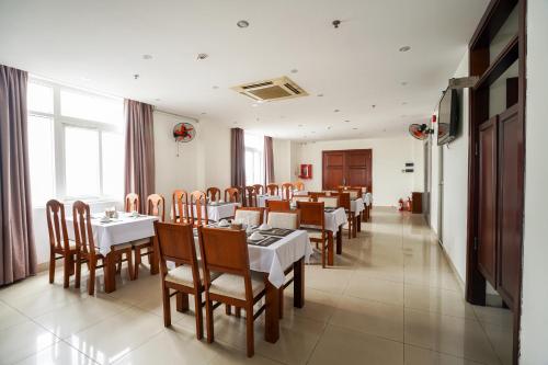 a dining room with tables and chairs in a restaurant at Sunview Beach Hotel Danang in Da Nang