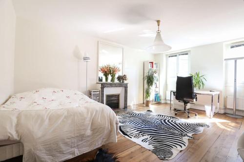 - une chambre avec un lit, un bureau et une cheminée dans l'établissement Central and Parisian style - 3 bedrooms, à Paris