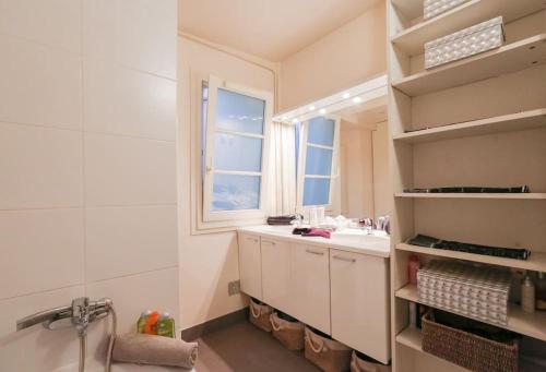 une salle de bain avec un lavabo et un miroir dans l'établissement Central and Parisian style - 3 bedrooms, à Paris