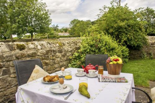 a table with food and fruit on it at Swallows Nest Holiday Cottage in Cockfield
