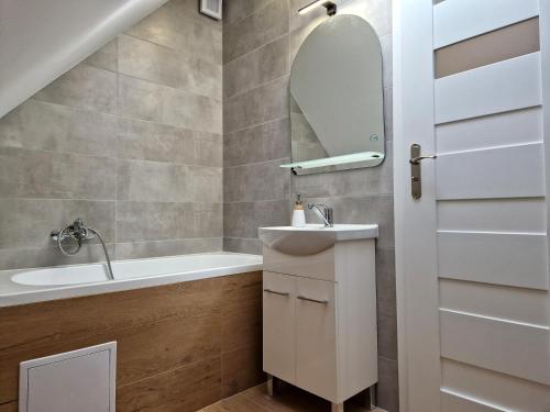 La salle de bains est pourvue d'un lavabo, d'une baignoire et d'un miroir. dans l'établissement Apartmány Lipovka, à Lipová-lázně