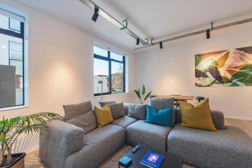 a living room with a couch and windows at Inner City Apartments - 1 in Nelson
