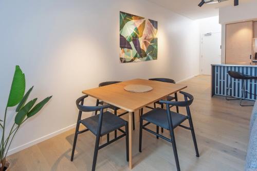 a table and chairs in a room with a painting at Inner City Apartments - 1 in Nelson