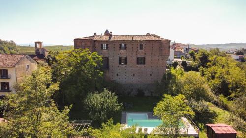 an old brick building with a pool in front of it at Agriturismo Ma Che Bel Castello in Mombaruzzo