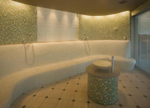 a bathroom with a tub and a sink in it at 焼津グランドホテル in Hanazawa