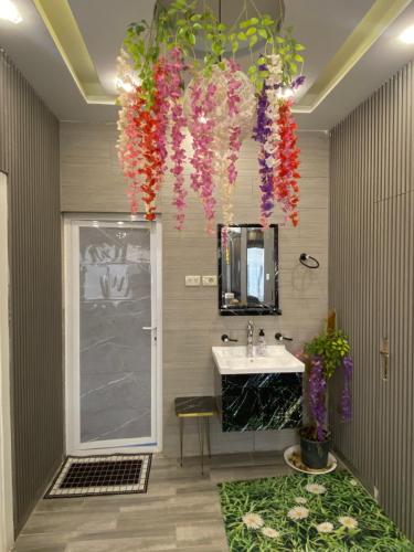 a bathroom with a sink and a mirror and flowers at شاليه ڤيو VIEW Chalet in Sowayma