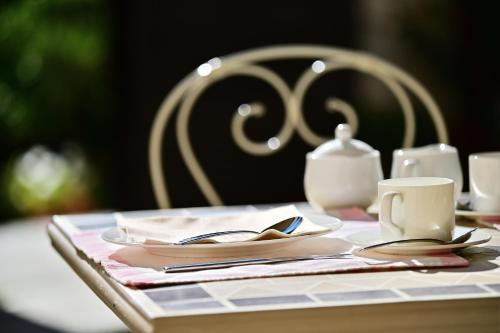a table with a plate and a cup and a tea pot at Agriturismo Ma Che Bel Castello in Mombaruzzo