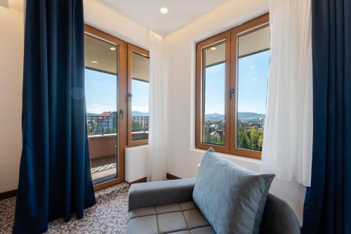 a living room with a couch and large windows at Queen of Zlatibor in Zlatibor