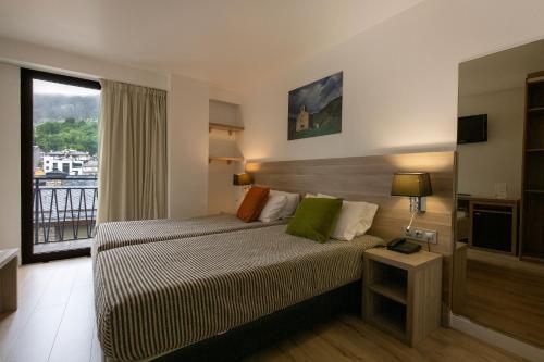 a hotel room with a bed and a window at Hotel Del Pui in La Massana