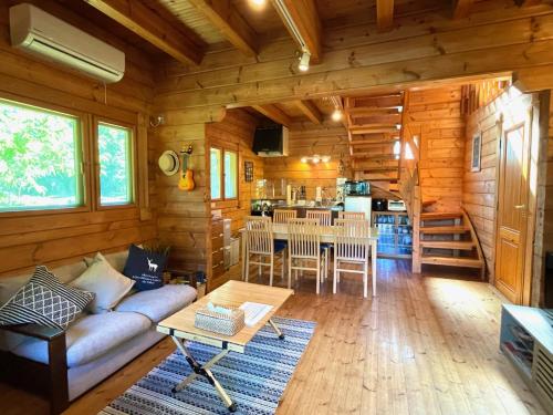 a living room and kitchen in a log cabin at Sunny Side Cottage in Shimoda