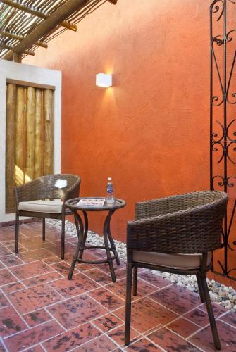two chairs and a table in a room with an orange wall at Abayomi Hotel in Ilhabela