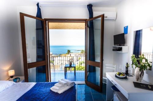 Schlafzimmer mit einem Bett und Meerblick in der Unterkunft Hotel Bellavista S'Archittu in S'archittu Cuglieri