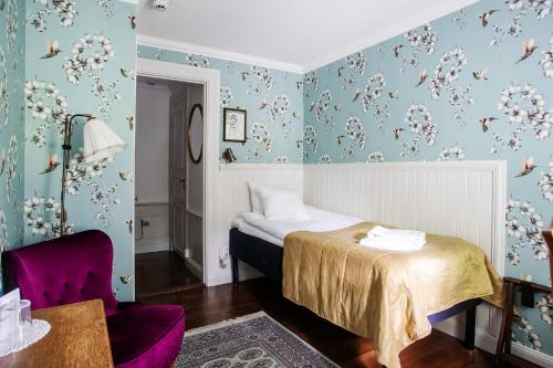 - une chambre avec un lit et une chaise violette dans l'établissement Grythyttans Gästgivaregård, à Grythyttan