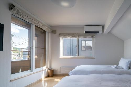 a bedroom with two beds and a large window at Casi 15 in Furano