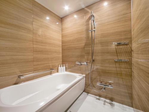 a bathroom with a white tub and a shower at Oriental Hotel Tokyo Bay in Urayasu