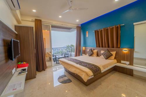 a bedroom with a large bed with a blue wall at Polsburg Panchgani in Panchgani