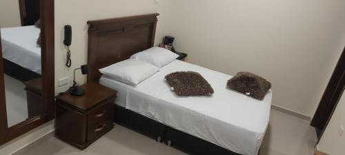 a bed with two pillows on it in a room at APARTAHOTEL LION in Tuluá