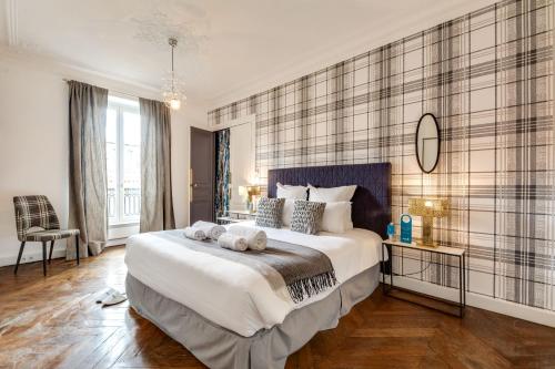 une chambre avec un grand lit avec deux serviettes dessus dans l'établissement Sweett - Rue de Rivoli, à Paris